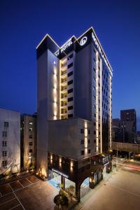 a hotel building with a sign on top of it at Notte La Mia Hotel in Busan