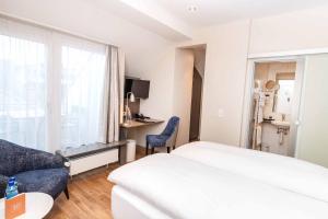 een hotelkamer met een bed, een bank en een raam bij Sorell Hotel Rex in Zürich