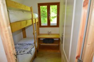 a small room with a bunk bed and a window at Chalet - Moulin du Squiriou in Berrien