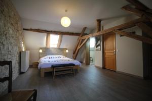 a bedroom with a bed in a room with wooden beams at B&B Le Corbier in Herry