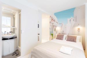 1 dormitorio blanco con 1 cama grande y lavamanos en VISIONAPARTMENTS Baarerstrasse - contactless check-in, en Zug