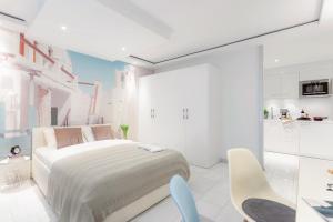 a white bedroom with a bed and two chairs at VISIONAPARTMENTS Baarerstrasse - contactless check-in in Zug