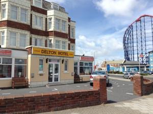 a building on a street with a roller coaster at Delton Hotel in Blackpool