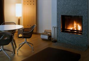a living room with a table and a fireplace at The Omnia in Zermatt