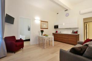uma sala de estar com um sofá, uma mesa e uma cozinha em Opera 19 Luxury Apartment em Florença
