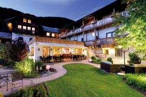 魏森湖Hotel zum Weissensee的一座前面有草坪的大楼