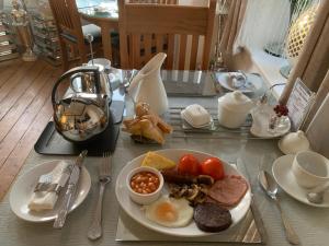 een tafel met een bord ontbijtproducten erop bij Abbey House in Llandudno