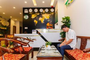 a man sitting in a room with a table at Tre Việt Tuy Hòa Hotel in Tuy Hoa