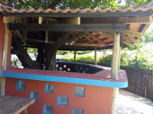 a pergola with a table in a garden at Tri M Waves Lodge in Ponta do Ouro
