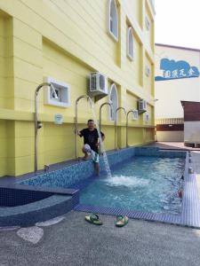 a man is standing in a swimming pool at Dream Ocean View B&B in Magong