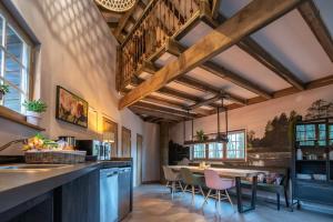 a kitchen with wooden ceilings and a table with chairs at Boomhut Drouwenerzand in Drouwen