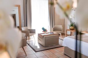 ein Hotelzimmer mit einem Bett, einem Tisch und Stühlen in der Unterkunft Villa Favorita - Parkhotel Delta in Ascona