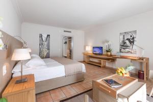 Schlafzimmer mit einem Bett und einem Schreibtisch mit einem TV in der Unterkunft Villa Favorita - Parkhotel Delta in Ascona