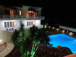 a swimming pool in front of a house at night at Perla Beach in Agia Marina Nea Kydonias