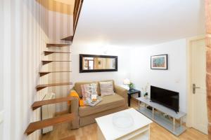 a living room with a couch and a staircase at Apartamentos Puerta Del Sol I in Madrid