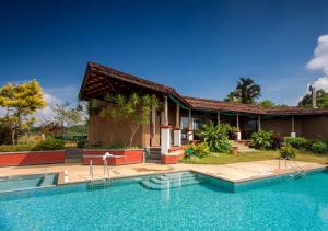 une maison avec une piscine en face d'une maison dans l'établissement Heritage Resort Coorg, à Madikeri