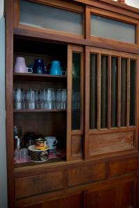 a wooden cabinet with cups and dishes in it at 履舍民宿Footinn in Taitung City