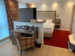 ein Hotelzimmer mit einem Bett und einem Schreibtisch in der Unterkunft Gästehaus Alpinia in Berlin