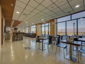 塔拉尤埃拉的住宿－Hospedium Hotel Valles de Gredos Golf，用餐室设有桌椅和窗户。