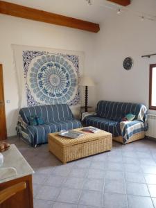 - un salon avec deux canapés bleus et une table dans l'établissement " le bosquet fruité en Provence Occitane, à Bagnols-sur-Cèze