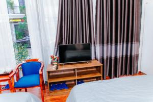 a bedroom with a tv on a desk next to a window at Tre Việt Tuy Hòa Hotel in Tuy Hoa