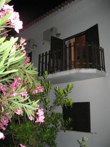 a balcony of a house with pink flowers at Casa Morgado in Almeida