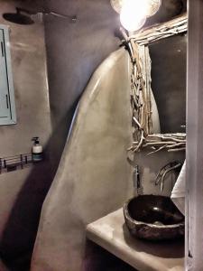a bathroom with a stone sink and a mirror at Villa Arion in Batsi