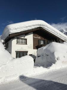 a building covered in snow with a pile of snow at Studio in Klosters in Klosters