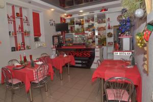 a restaurant with red tables and chairs with christmas decorations at Отель "Экспресс" in Zhytomyr