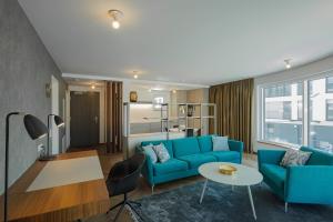 uma sala de estar com um sofá azul e uma mesa em DD Suites Serviced Apartments em Munique