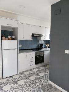 a kitchen with white cabinets and a stove top oven at Prado Design Apartment in Gandía