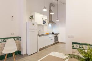een keuken met een witte koelkast en een stoel bij S'Estacio in Bunyola