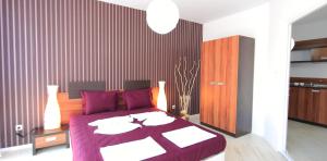 1 dormitorio con 1 cama grande con manta morada en Hotel Rainbow 3 Resort Club, en Sunny Beach