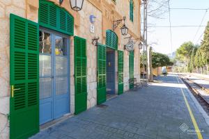 a building with green shutters on a street at S'Estacio in Bunyola