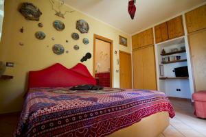a bedroom with a bed with red pillows and plates on the wall at La Dimora le Fumarole Rooms in Ercolano