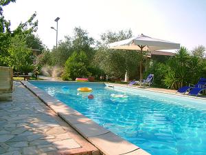 a large blue swimming pool with an umbrella and chairs at TENUTA MARTINO in Aquara
