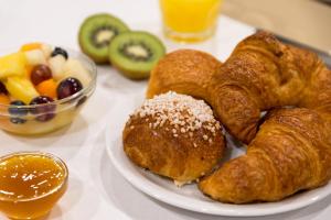 a plate of pastries and fruit on a table at Hôtel Le Seize, Nice Centre in Nice