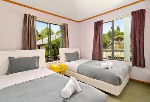 a bedroom with two beds and a window at Red Door holiday house in Rotorua