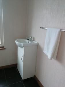 La salle de bains est pourvue d'un lavabo et d'une serviette blanche. dans l'établissement Emangunini Guest house, à Richards Bay
