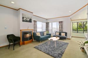 a living room with a couch and a fireplace at Red Door holiday house in Rotorua
