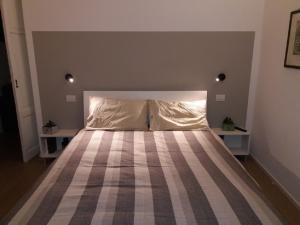 1 dormitorio con 1 cama grande con colcha a rayas en Le Quinte del Duomo en Como