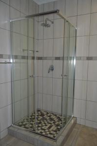 a shower with a glass enclosure in a bathroom at Emangunini Guest house in Richards Bay