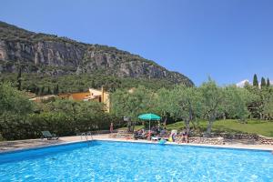 a swimming pool with a mountain in the background at Appartamenti Pratone in Garda