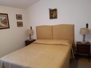una camera con un letto e due comodini con lampade di A casa di Berta a Pietrasanta