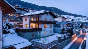 una casa con nieve en el suelo en una ciudad en Appartements Jeitner en Wenns