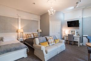 a bedroom with a bed and a couch and a tv at No 46 Marine Terrace in Aberystwyth