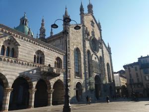 a street light in front of a building with a clock tower at Le Quinte del Duomo in Como