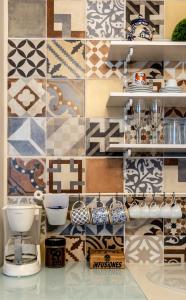 a kitchen with a tile wall and a counter with dishes at Oporto Coliseum Residence in Porto