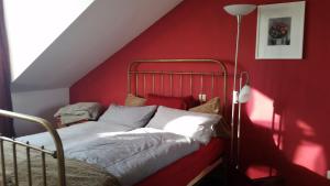 1 dormitorio rojo con 1 cama con pared roja en Ruhige Wohnung an der Uni en Düsseldorf