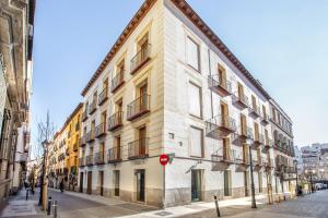 un gran edificio blanco en una calle de la ciudad en Slow Suites Chueca, en Madrid